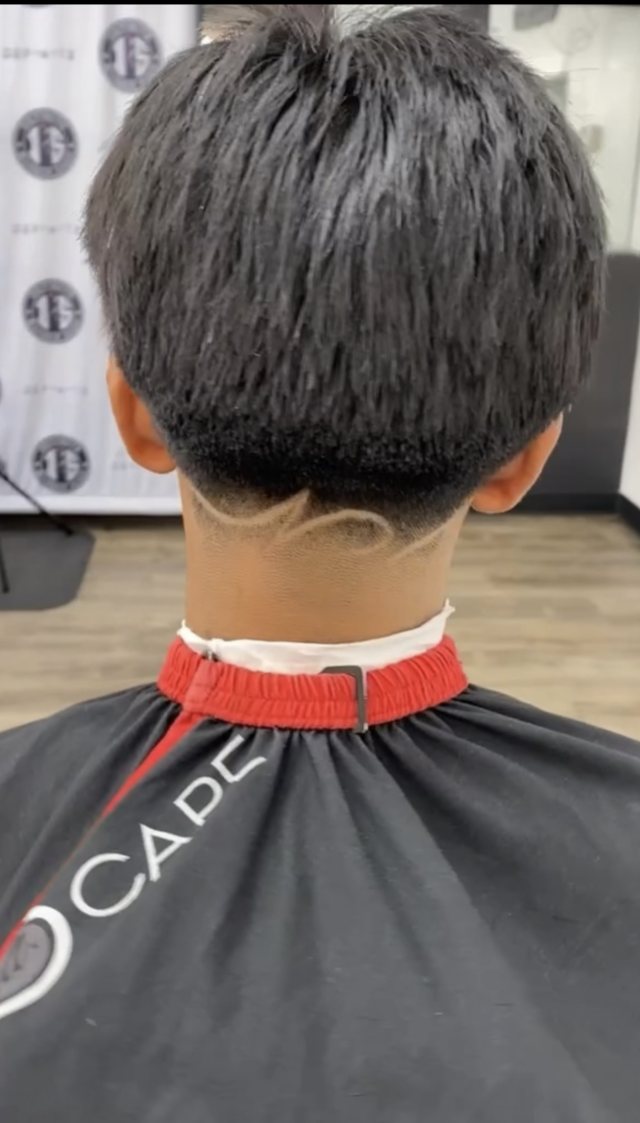 Back view of a fresh haircut with a curved neckline design detail