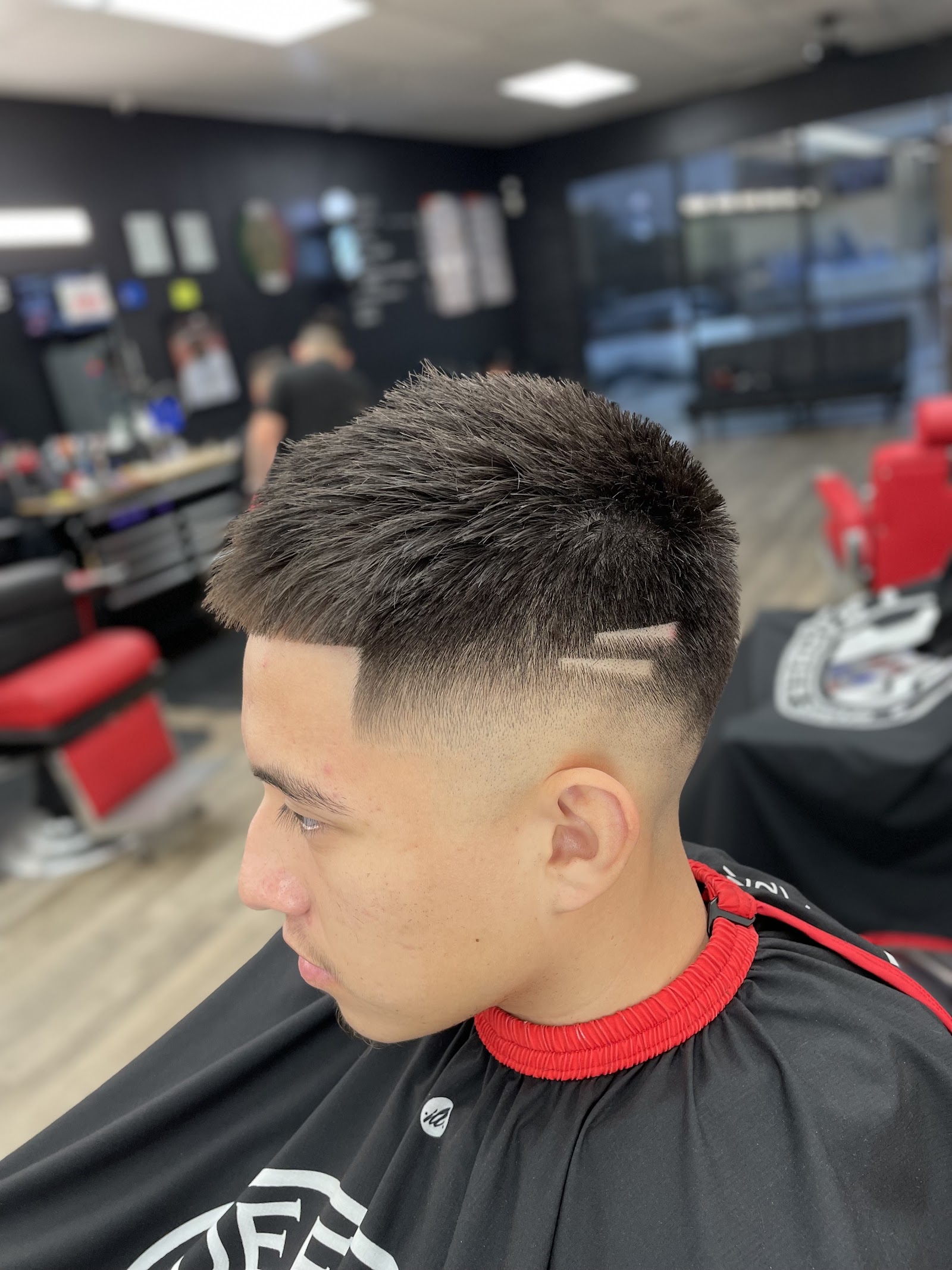 Close-up of a fresh mid skin fade haircut with textured top and eyebrow slit design